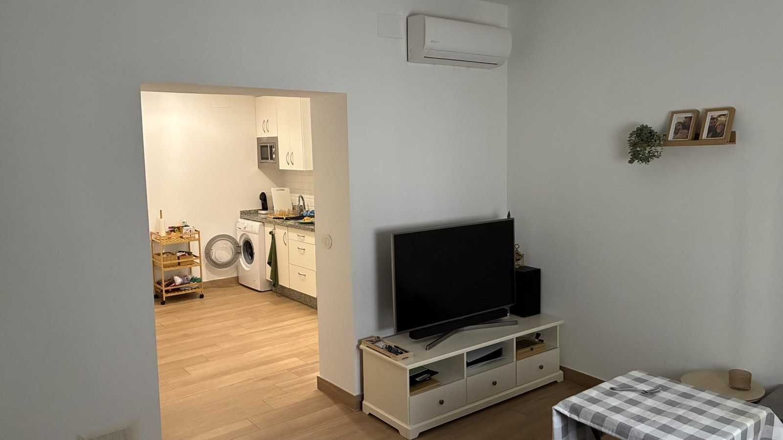Zona de estar con televisión y paso a la cocina