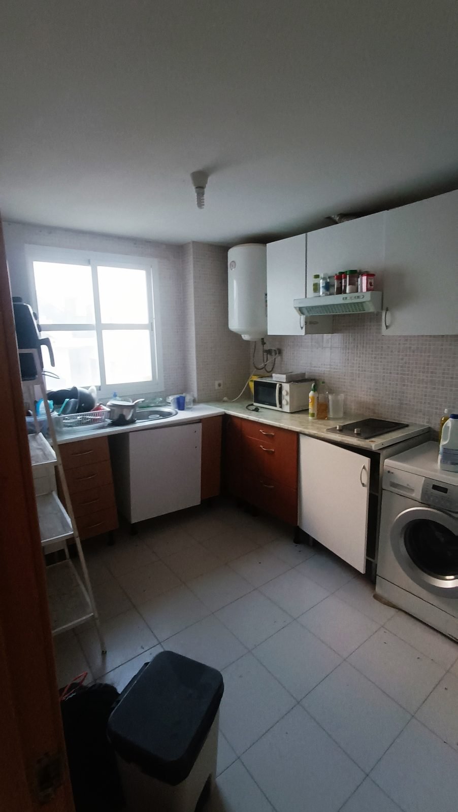 Cocina antigua con muebles de madera, bajo la misma ventana