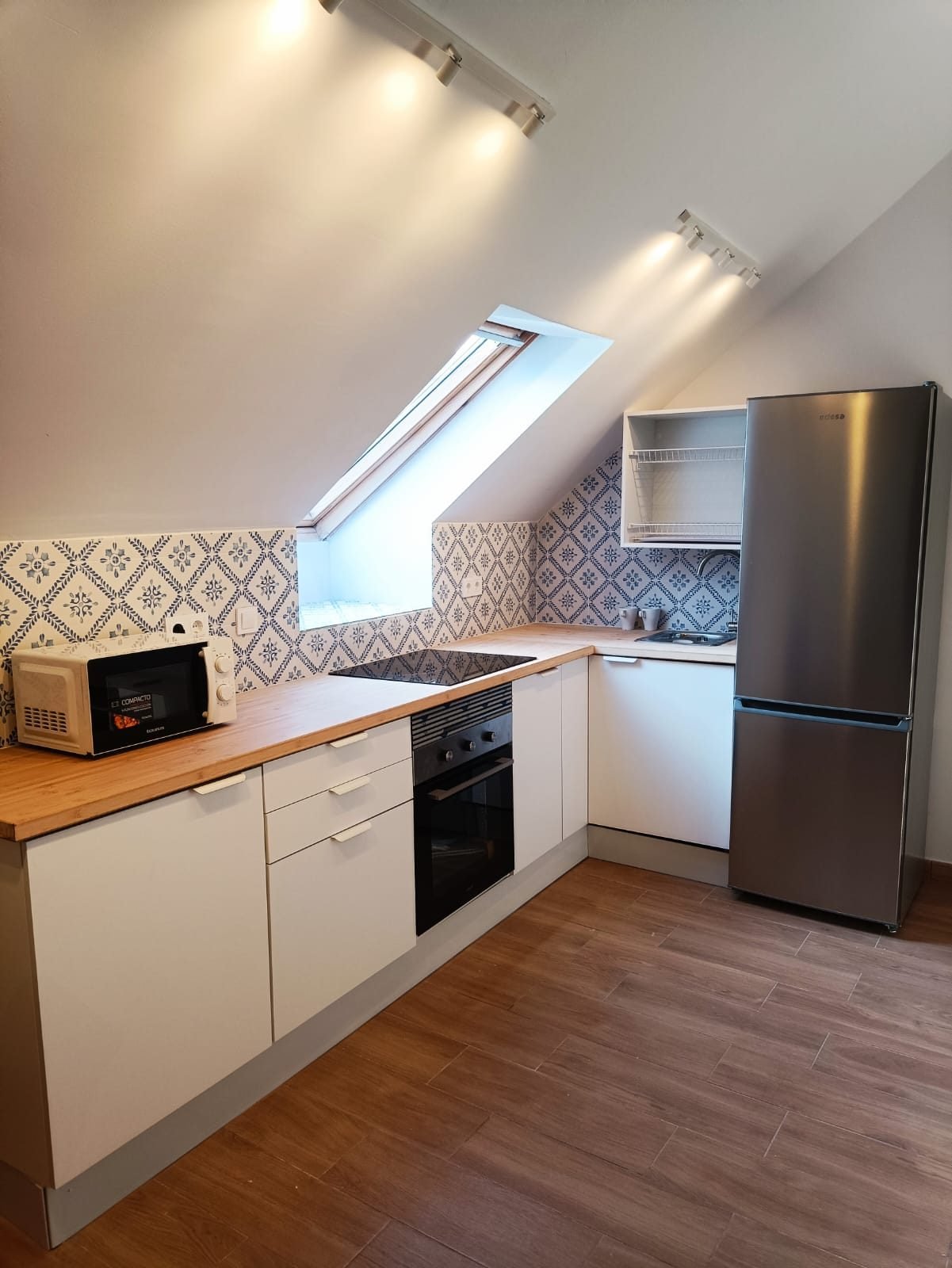 Cocina con ventana de cubierta y frigorífico