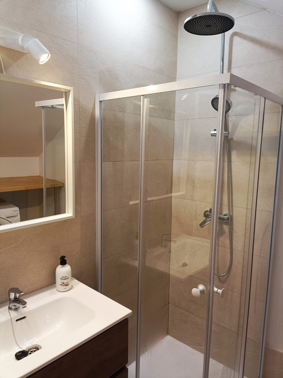Baño con ducha de mampara y lavabo