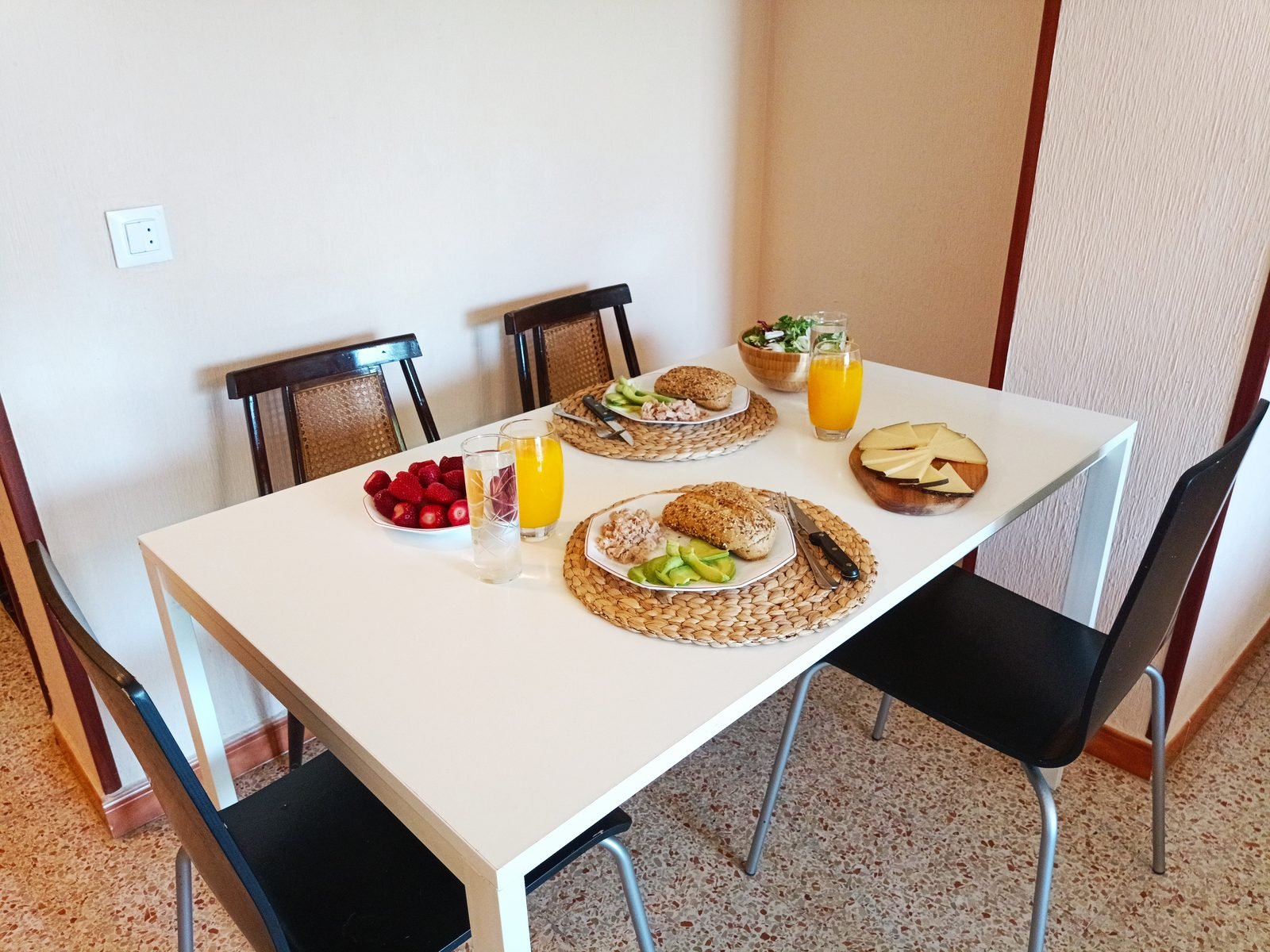 Mesa de comedor blanca con desayuno servido