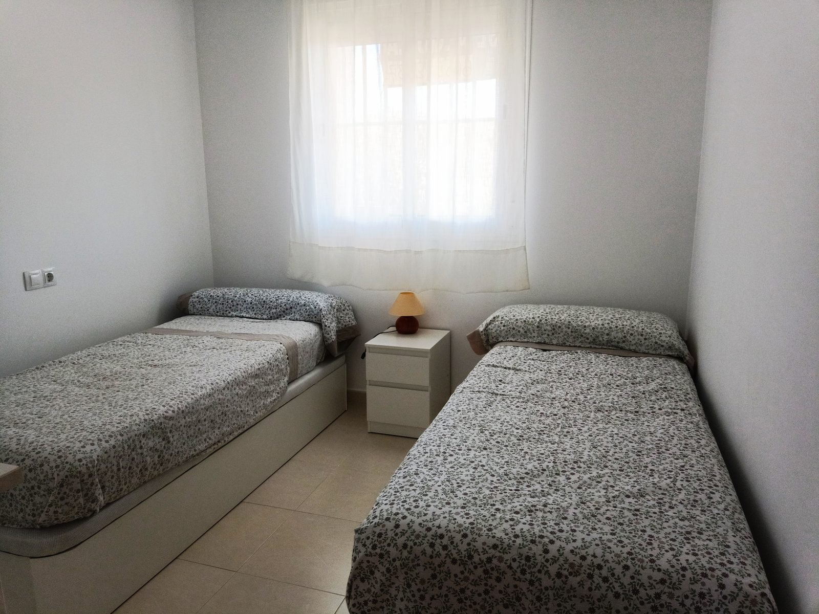 Dormitorio con dos camas individuales y una ventana