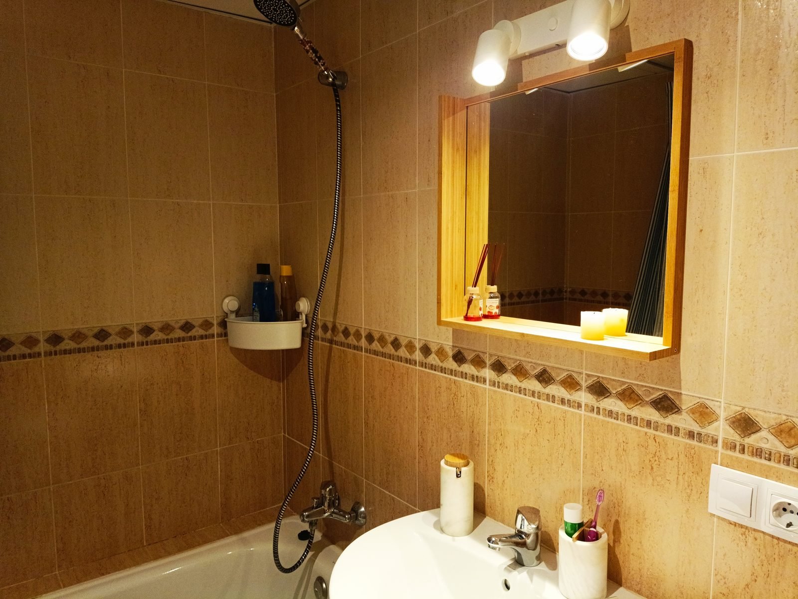 Baño con lavabo, espejo y bañera con ducha